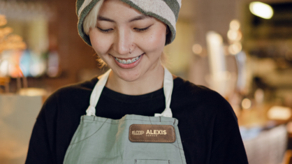 A smiling employee wearing a custom engraved name tag